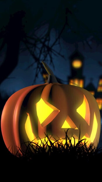 A Halloween Pumpkin Wallpaper featuring a brightly glowing jack-o'-lantern in dark grass with a spooky house in the background
