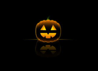 A minimalist Halloween Pumpkin Wallpaper featuring a glowing jack-o'-lantern with a reflection on a dark background