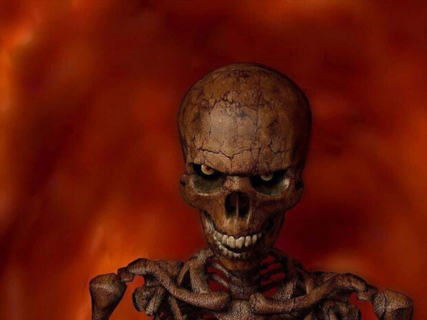Halloween Skeleton Wallpaper featuring a close-up of a cracked ancient skeleton with glowing eyes against a fiery orange background