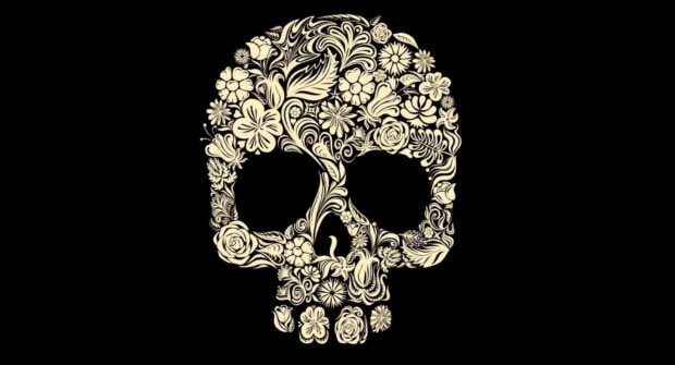 An artistic Halloween Skeleton Wallpaper featuring a skull intricately designed with elegant floral patterns in cream on a stark black background