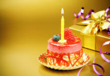 Its My Birthday Wallpaper featuring an elegant individual birthday cake with a lit yellow candle, raspberry, and blueberry on a shimmering gold background with a gift