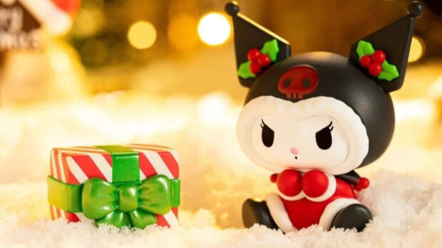 A charming Kuromi Christmas wallpaper featuring a figurine in a Santa outfit sitting in snow next to a festive gift box