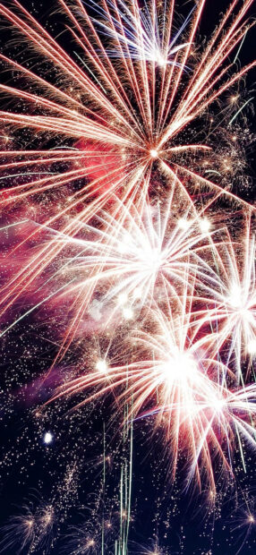 New Years Eve Wallpaper showcasing multiple red and white fireworks exploding across the dark night sky
