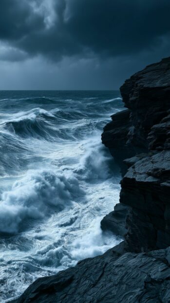 A dark and moody Ocean Wallpaper capturing powerful stormy waves crashing against a rugged rocky cliff in a vertical format