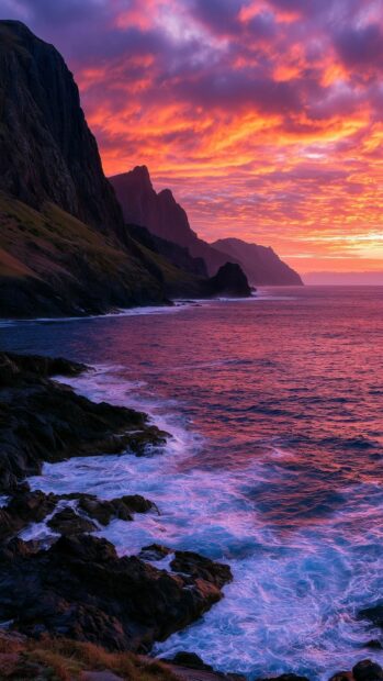 Ocean wallpaper featuring a dramatic coastal sunset with rugged cliffs and waves crashing on rocks