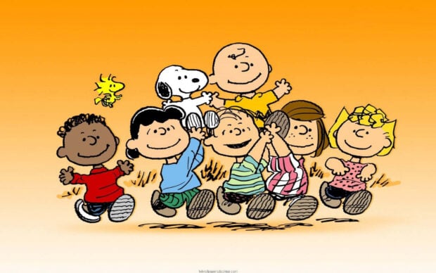 A joyful Snoopy Fall Wallpaper depicting the Peanuts gang, including Snoopy and Woodstock, running happily together on an orange background