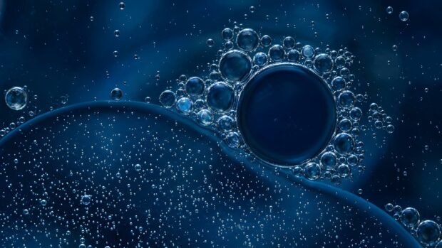 An abstract digital wallpaper featuring a macro shot of blue oil and water bubbles, creating a unique texture