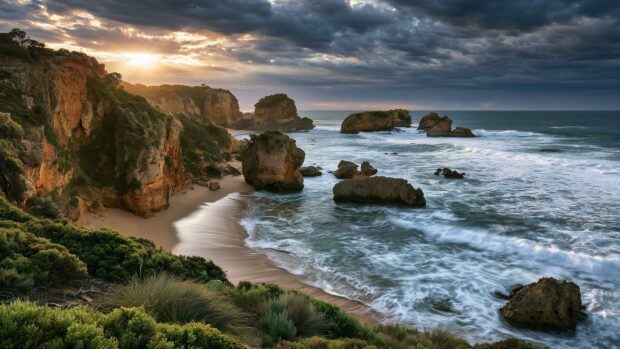 Beach wallpaper showing a dramatic sunset over rugged cliffs and ocean rock formations with crashing waves