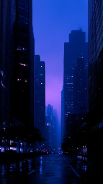 Dark Aesthetic Wallpaper featuring a city street at night with tall buildings and a vibrant purple-blue sky