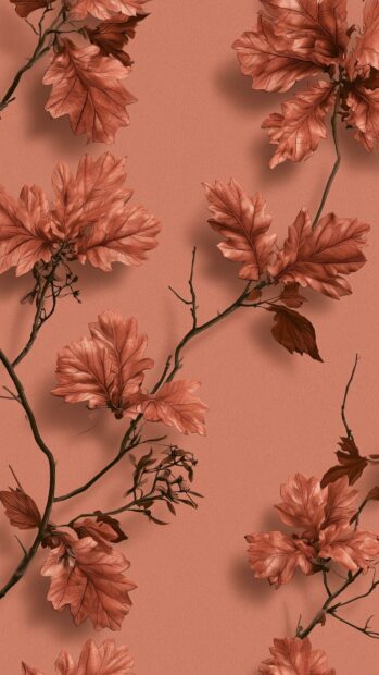 Fall aesthetic wallpaper featuring a seamless pattern of brown oak leaves and branches on a soft peach background