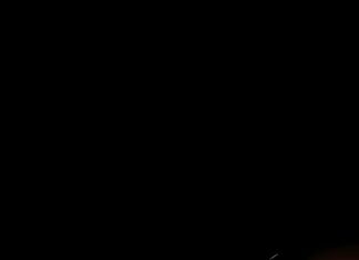 Lightning Mcqueen Wallpaper showing the car racing at high speed on a dark track with motion blur and sparks