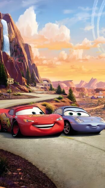 A charming Lightning Mcqueen Wallpaper featuring him with Sally Carrera on a scenic road with a waterfall and mountains