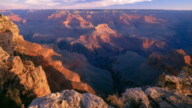 A breathtaking nature wallpaper showcasing the vast landscape of the Grand Canyon bathed in the warm glow of a sunset
