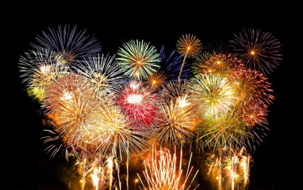 A spectacular New Year Aesthetic Wallpaper showcasing numerous colorful fireworks exploding brightly against a dark night sky