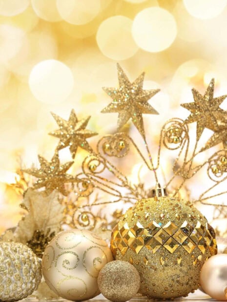 A New Year Aesthetic Wallpaper featuring a collection of sparkling golden Christmas and New Year ornaments with a soft bokeh background