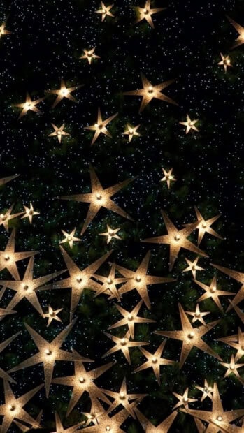 A New Year Aesthetic Wallpaper showcasing many illuminated golden star lights against a dark, starry background