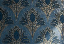 An elegant retro wallpaper featuring a repeated Art Deco pattern of golden peacock feathers on a textured blue background