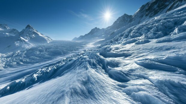 A stunning Winter Wallpaper featuring a sunny mountain glacier landscape with vast snowfields and clear blue sky
