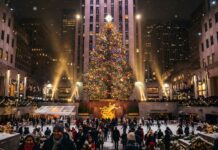 The iconic Rockefeller Center Christmas tree brightly lit, with people ice skating below, making a perfect New York Christmas wallpaper