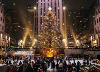 The iconic Rockefeller Center Christmas tree brightly lit, with people ice skating below, making a perfect New York Christmas wallpaper