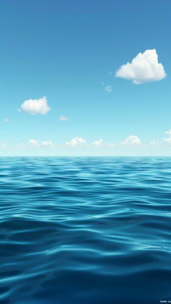 A calm sea with gentle ripples and a clear blue sky.