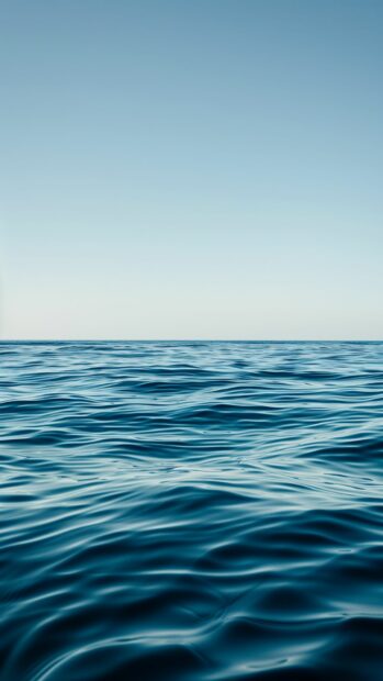 A calm sea with gentle ripples and a clear blue sky, Ocean iPhone Wallpaper.