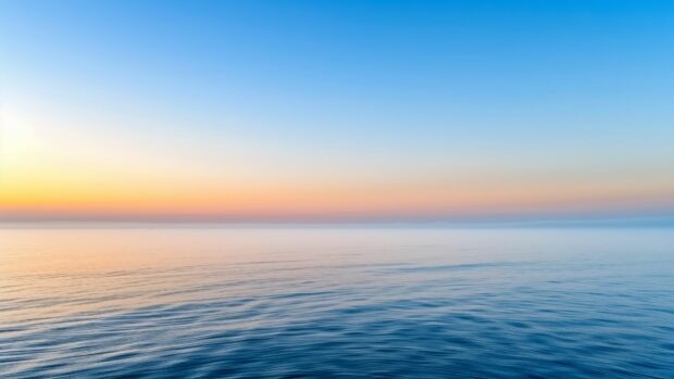 A misty morning over a calm ocean with light fog.