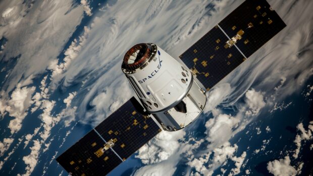 A serene image of the SpaceX Dragon capsule orbiting Earth, with the planet's blue oceans and white clouds in the background, Desktop wallpaper.