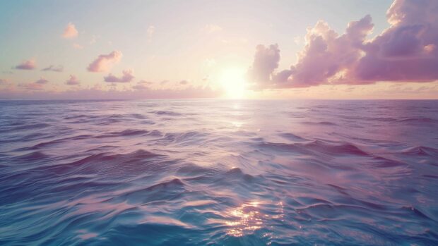 A serene ocean desktop wallpaper at dawn with soft pastel colors in the sky and water.