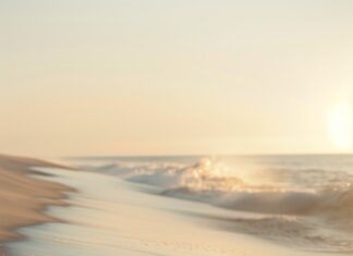 An aesthetic beach 4K iPhone wallpaper with delicate seafoam patterns on the sand.