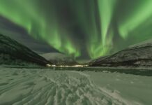 Free Space desktop background with A vibrant Northern Lights dancing over a snowy landscape wallpaper.