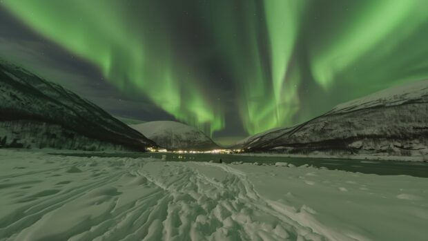 Free Space desktop background with A vibrant Northern Lights dancing over a snowy landscape wallpaper.