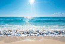 HD Desktop Wallpaper with a bright sunny day over a clear blue ocean with gentle waves.