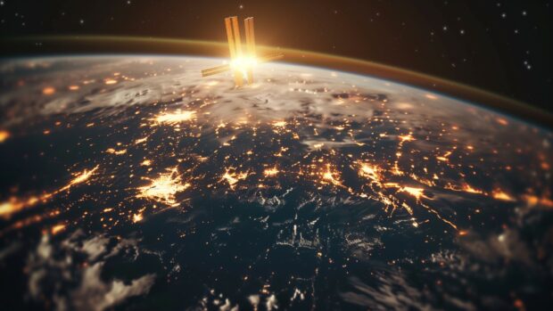 The International Space Station at sunset, with golden light reflecting off its surface and solar panels.