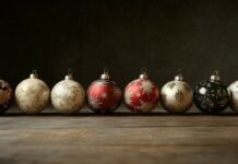 Colorful Christmas ornaments with gold and red designs on a rustic wooden surface.