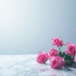 A simple bouquet of pink roses on a marble surface, with a clean, white background.