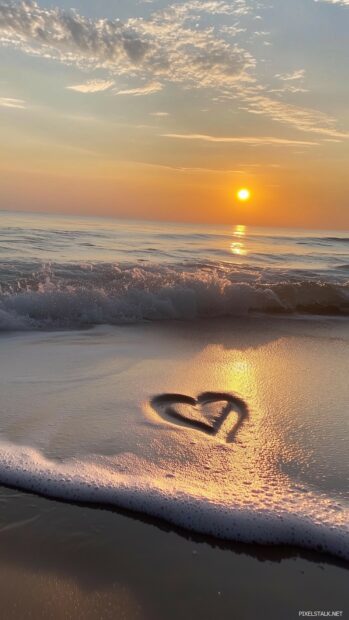 A sunset beach scene with a heart drawn in the sand, waves gently washing up to the shore, Beautiful Valentine iPhone Wallpaper.