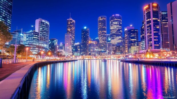 Desktop Wallpaper 1920x1080 features a night scene of a city waterfront with reflections of city lights dancing on the water.