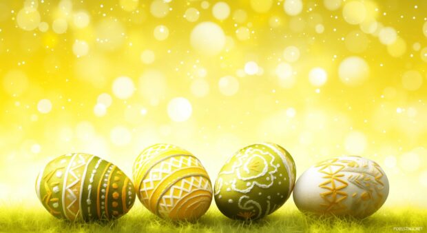 Field of colorful Easter eggs set against a sunny, springtime background.