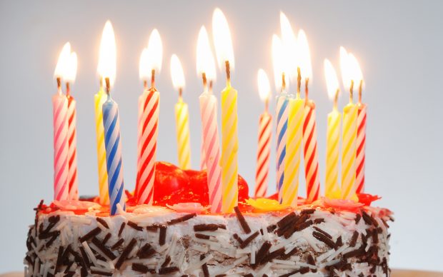 a birthday cake with lighted candles.