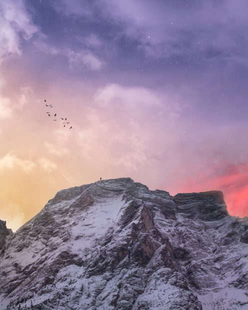 4K Cool iPhone mountain covered with snow under blue and orange skies.