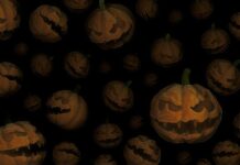 Eerie Halloween pumpkins with sinister carved faces on dark background.