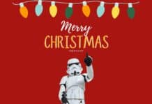 Festive Christmas string lights with a Star Wars stormtrooper figure pointing upward against a red background.