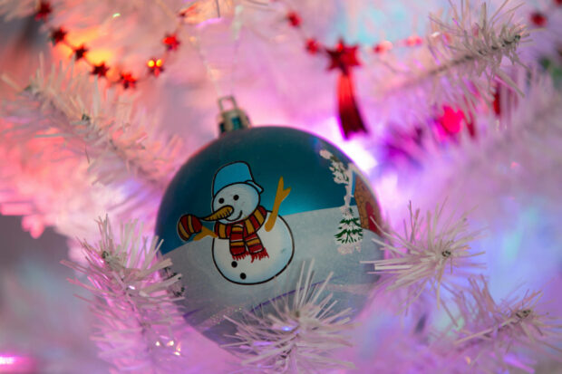 Get festive with this snowman wearing Christmas lights Wallpaper.