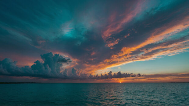 Ethereal summer sky wallpaper with hues of teal and turquoise blending into a soft sunset.