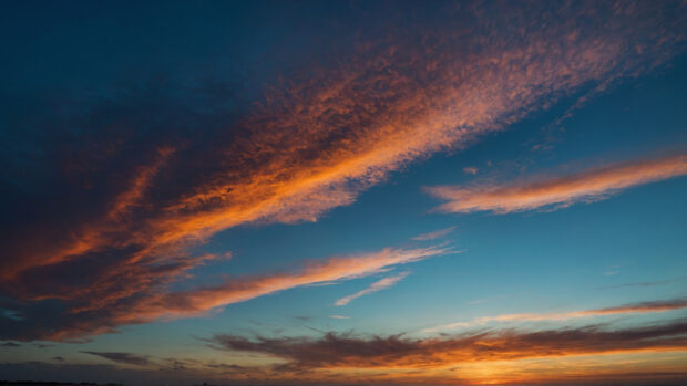 Vibrant summer sky wallpaper with a gradient of blue transitioning to orange at the horizon.